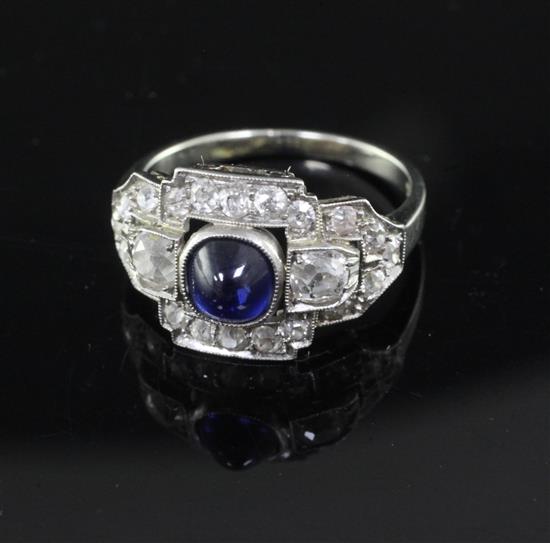 An Art Deco cabochon sapphire and diamond cluster ring, white metal setting (tests as 14ct), size K
